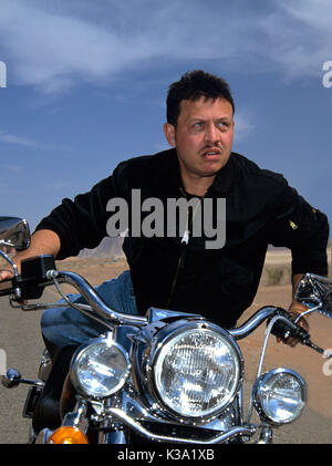 King Abdullah ll of Jordan riding his motorcycle at Wadi Rum while filming travel documentary Jordan: The Royal Tour circa 2000 Stock Photo