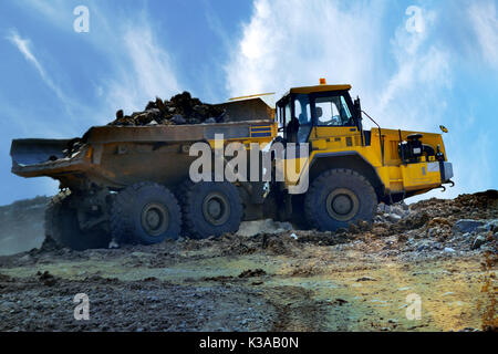 Big industrial tipper truck goes on mountain road, big roadworking tipper construction concept Stock Photo