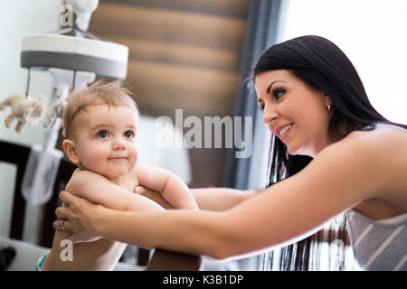 Mother putting baby to sleep at the crib Stock Photo