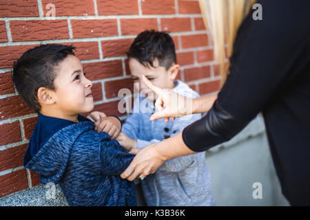 Teacher Stopping Two Boys Fighting In Playground Stock Photo