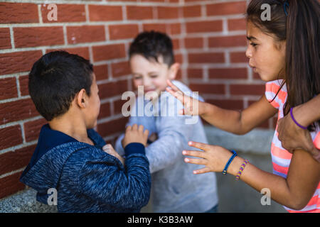 Stopping Two Boys Fighting In Playground Stock Photo