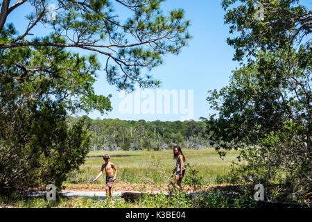Georgia,Jekyll Island,barrier island,pathway,trail,Clam Creek water Picnic Area,girl girls,female kid kids child children youngster youngsters youth y Stock Photo