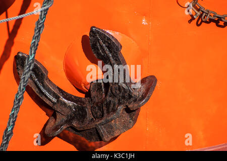 Red tugboat close up black anchor detail Stock Photo