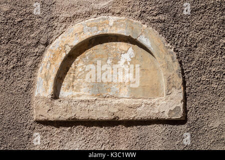 Semicircular walled up small old window Stock Photo