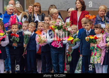 NOVOKUZNETSK, KEMEROVO REGION, RUSSIA - SEP, 1, 2017: Meeting with the first-grade pupils and teacher at schoolyard. The day of knowledge in Russia. Stock Photo