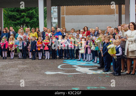 NOVOKUZNETSK, KEMEROVO REGION, RUSSIA - SEP, 1, 2017: Meeting with the first-grade pupils and teacher at schoolyard. The day of knowledge in Russia. Stock Photo