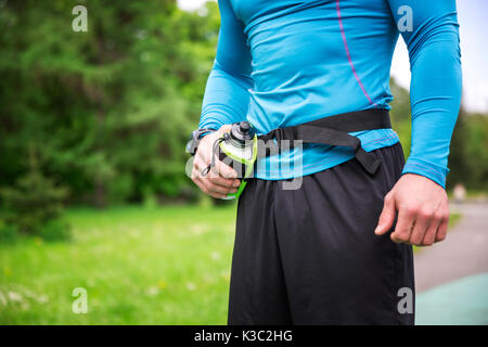 A photo of person in sporty outfit holding bidon with water. Stock Photo