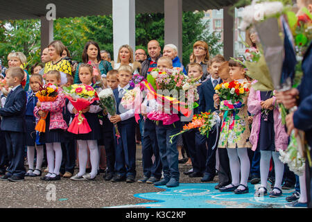 NOVOKUZNETSK, KEMEROVO REGION, RUSSIA - SEP, 1, 2017: Meeting with the first-grade pupils and teacher at schoolyard. The day of knowledge in Russia. Stock Photo