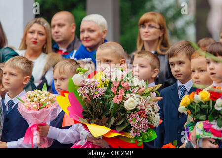 NOVOKUZNETSK, KEMEROVO REGION, RUSSIA - SEP, 1, 2017: Meeting with the first-grade pupils and teacher at schoolyard. The day of knowledge in Russia. Stock Photo