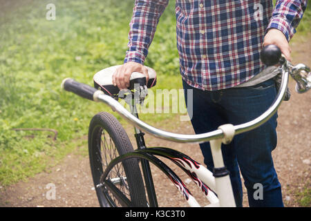 Cropped portrait of man standing outside holding bike Stock Photo