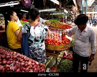 MARIKINA CITY, PHILIPPINES - AUGUST 28, 2017: Customers buy fresh vegetables from a vegetable store at a public market. Stock Photo