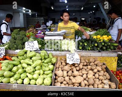 MARIKINA CITY, PHILIPPINES - AUGUST 28, 2017: A vendor sells fresh vegetable in a store at a public market. Stock Photo