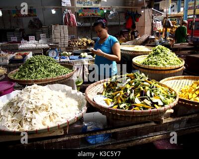 MARIKINA CITY, PHILIPPINES - AUGUST 28, 2017: A vendor sells fresh vegetable in a store at a public market. Stock Photo