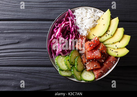 Raw Organic Ahi Tuna Poke Bowl with Rice and Veggies close-up on the table. Top view from above horizontal Stock Photo