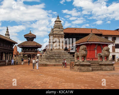 Ancient stone lions and the large white Fasidega Temple dedicated to Shiva  in Bhaktapur, on a background Blue Sky and wight clouds, Nepal Stock Photo