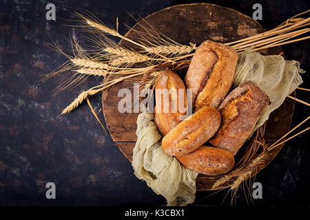 Assortment of baked bread and bun on a wooden background. Top view. Flat lay Stock Photo