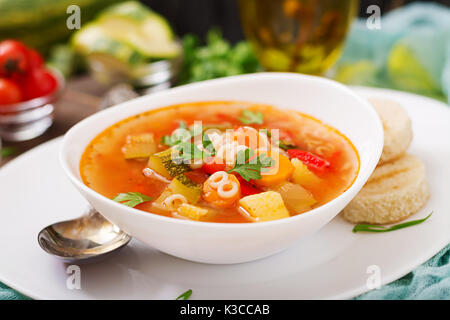 Minestrone - 'big soup', soup with many ingredients - a dish of Italian cuisine, light seasonal vegetable soup with pasta. Stock Photo