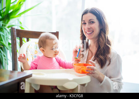 Mother feeding baby with spoon Stock Photo