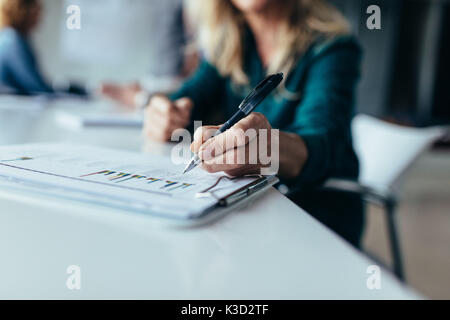 Focus on female hand pointing at chart. business woman doing statistical analysis of diagrams in office. Stock Photo