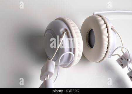 Isolated modern white headphone over a white reflected background. Stock Photo