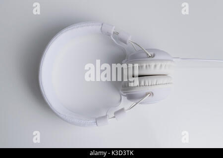 Isolated modern white headphone over a white reflected background. Stock Photo