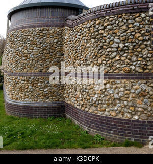 Curved decorative modern flint stone and blue engineering brick wall Stock Photo