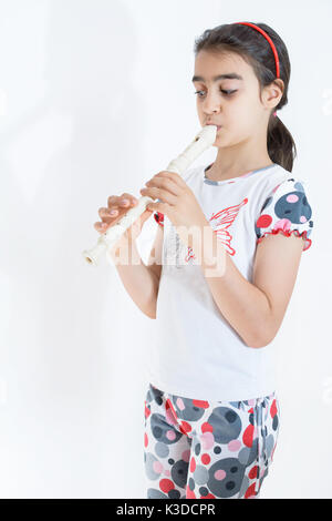 A little girl playing the flute Stock Photo