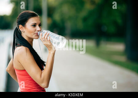Thirsty woman drinking water to recuperate Stock Photo