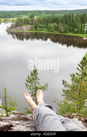 the girl swung his legs off the mountains and enjoying magnificent views. Freedom concept. Stock Photo