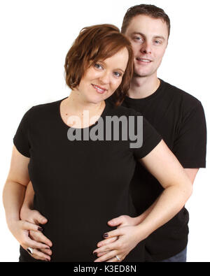 a young couple in studio with man behind holding wife's belly Stock Photo
