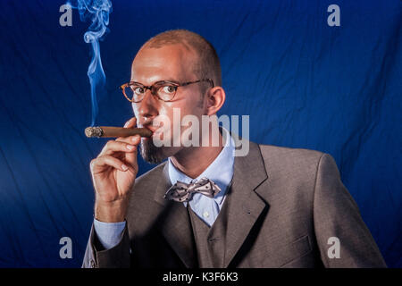 Cigar smoking man in suit with bow tie Stock Photo