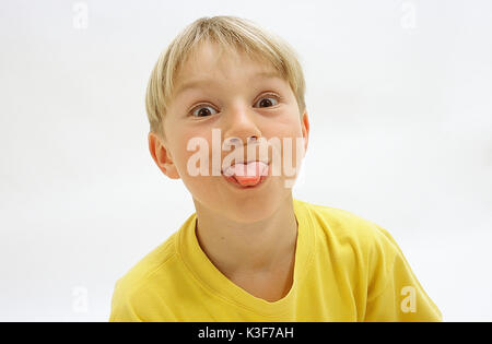 Blond boy sticks out the tongue Stock Photo