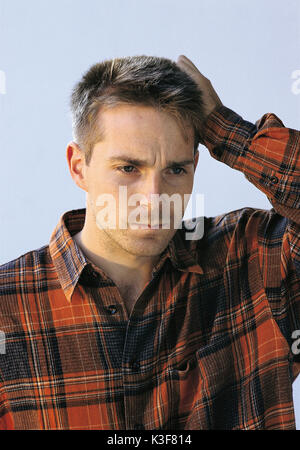 Young man grabs himself to the head / thinks Stock Photo