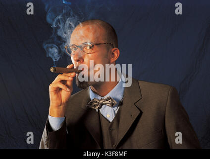 Cigar smoking man in suit with bow tie Stock Photo