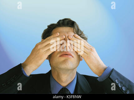 Man covers his eyes with the hands Stock Photo