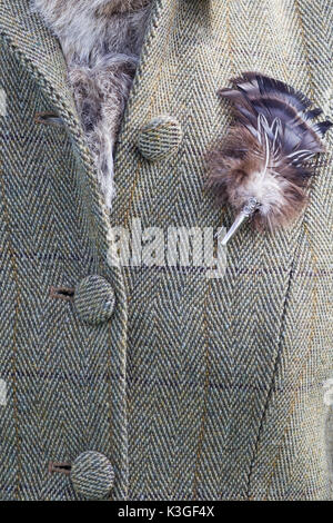 Tweed riding jacket with feather brooch Stock Photo