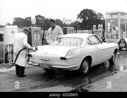 ROGER MOORE STAR OF THE SAINT WATCHING A GARAGE ATTENDANT FILL HIS VOLVO WITH PETROL Stock Photo