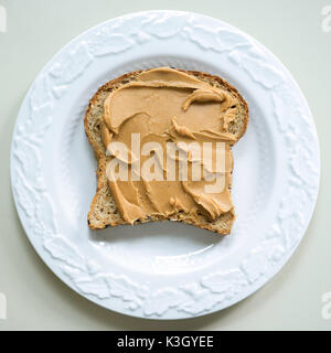 Peanut butter slathered on a slice of multi grain bread. Stock Photo