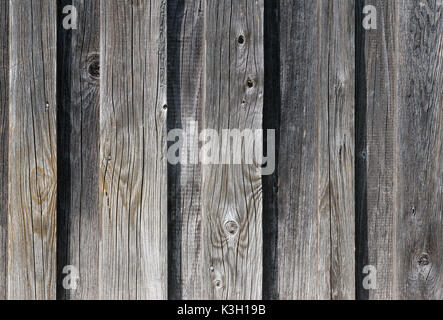 Weathered old wooden wall detail. Simple gray boards with knotholes and coarse grain nailed together. Outdoor. Backgrounds. Photo. Stock Photo