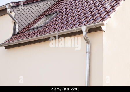 an rain drain pipe from the roof whit blue sky and clouds Stock Photo