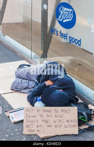 England, London, Oxford Street, Homeless Man Sleeping on Sidewalk Stock Photo