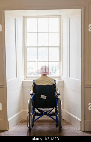 England, Elderly Lady in Wheelchair Looking out of Window Stock Photo