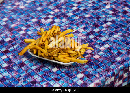 Fresh cut French fries on picnic table Stock Photo