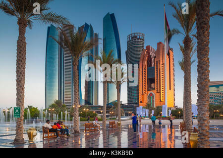 UAE, Abu Dhabi, Etihad Towers and Emirates Palace Hotel fountains, dusk Stock Photo