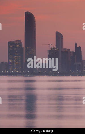UAE, Abu Dhabi, city skyline along the Corniche, dawn Stock Photo