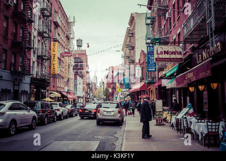 Typical Streetview with traffic and brick houses, fire stairs, pedestrians in Little Italy, Manhatten, New York, USA Stock Photo