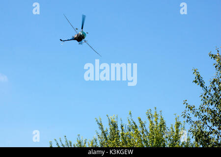 Crop sprayer duster helicopter, spraying mountains, fields and land with a blue sky on the background Stock Photo