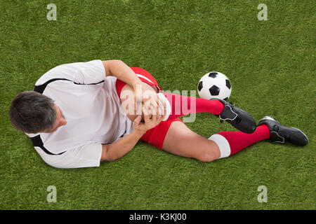 Male Soccer Player Suffering From Injury In Knee Stock Photo