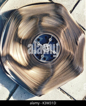 A metal spool with 2,000 feet of 35mm Technicolor safety film printed by the dye-transfer system. The extreme warping of the film indicatess that it is badly affected by a deterioration commonly known as 'the  vinegar syndrome'  This can make the film, as in this case, unshowable because of the film's buckled surface. Stock Photo