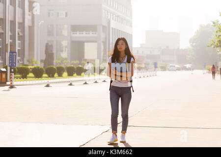 Girl holding the book Walks in Campus Park Stock Photo